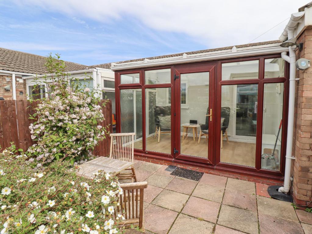 a conservatory with sliding glass doors on a house at Bedwine Cottage in Beadnell