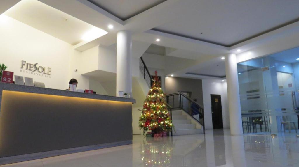 a christmas tree in the middle of a lobby at Fiesole Residence Inn in Dumaguete