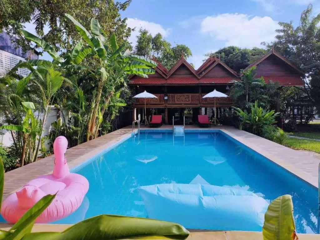 a pool with a pink flamingo in front of a house at Capital O923 Elephant at Baan Tawai in Bān Sawan