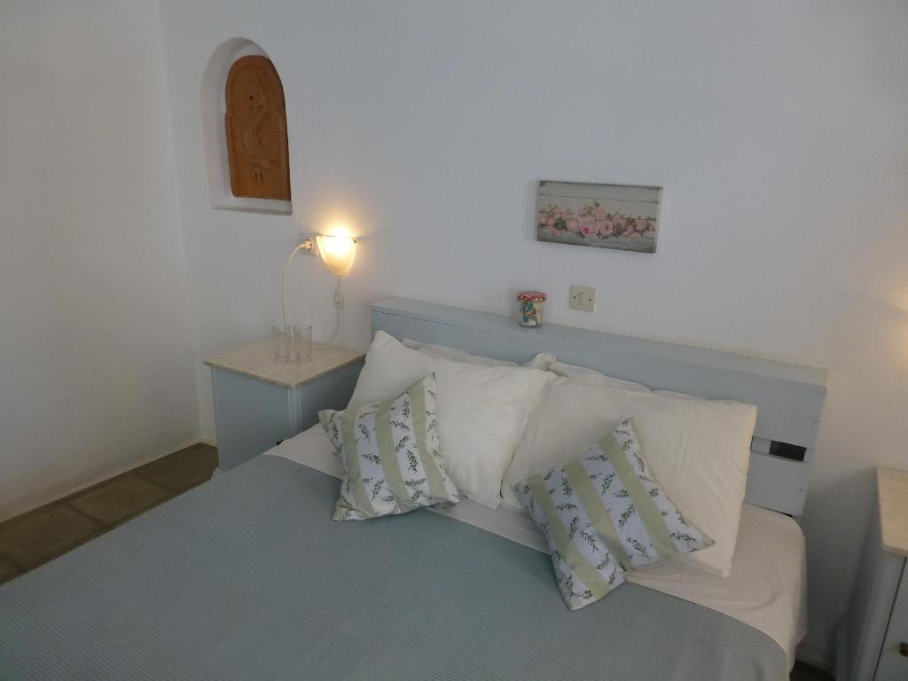 a bedroom with a bed with white pillows at Agistri Club Hotel in Skliri