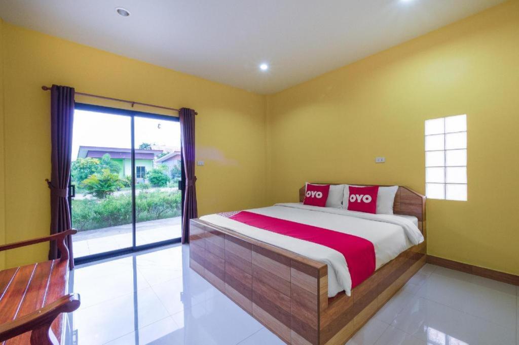 um quarto com uma cama e uma janela grande em OYO 1044 Vassana ResortÃ¢â‚¬â€¹ em Sattahip