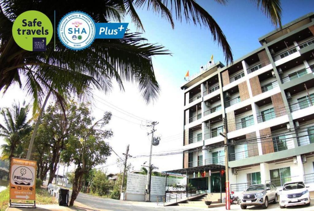 um hotel com uma palmeira em frente a um prédio em P Bliss Hotel em Phayao