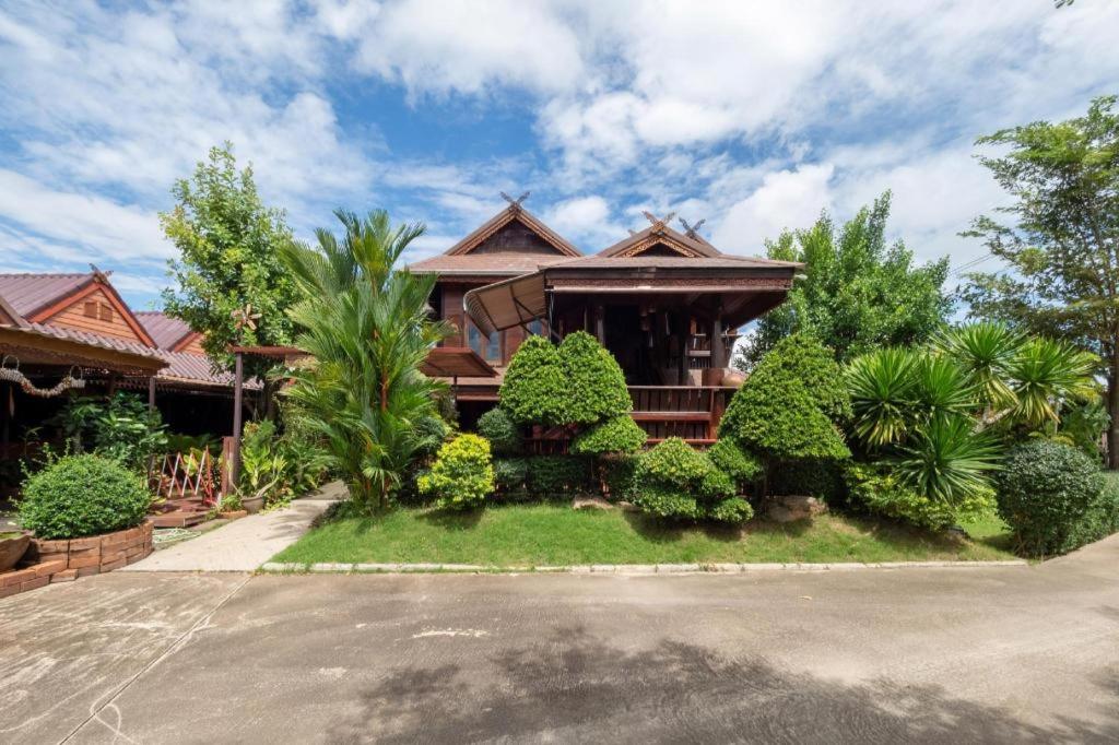 a house with trees and bushes in front of it at OYO 1128 Ban Suan Meesakul Resort in Ban Nong Chap Tao