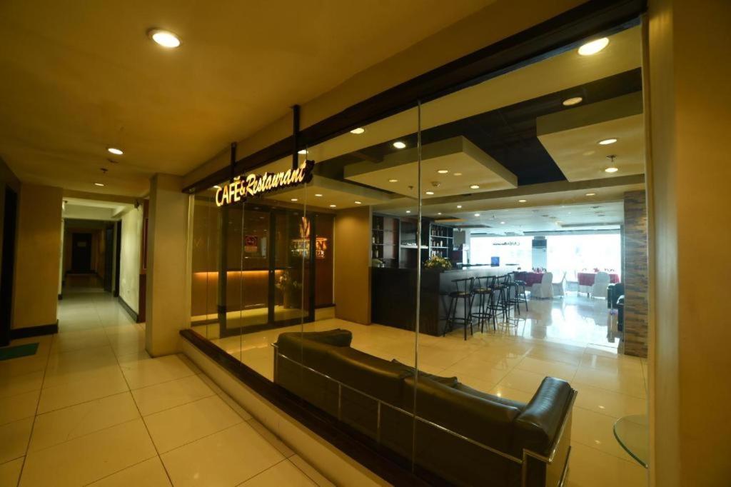 una hall di un ristorante con panchina e tavolo di Marcian Business Hotel a Zamboanga