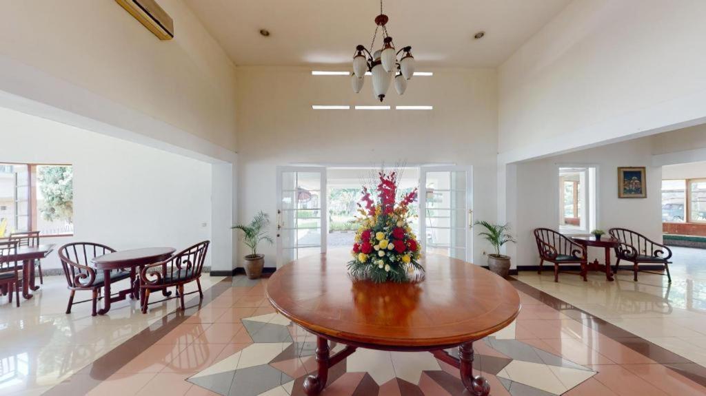 ein Esszimmer mit einem Tisch mit Blumen darauf in der Unterkunft Casa D' Ladera Hotel in Bandung