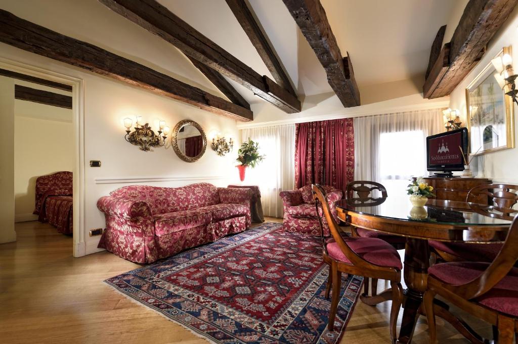 ein Wohnzimmer mit einem Sofa und einem Tisch in der Unterkunft Suites Torre Dell'Orologio in Venedig