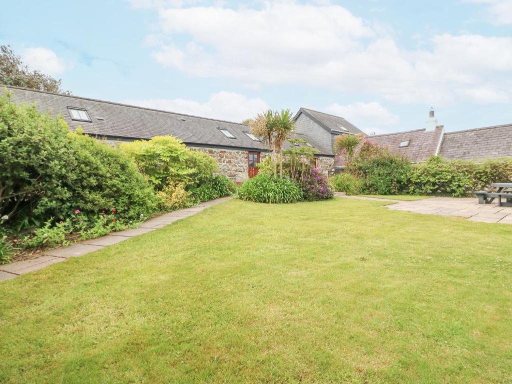 a garden with a lawn and a picnic table at The Old Dairy in Pwllheli