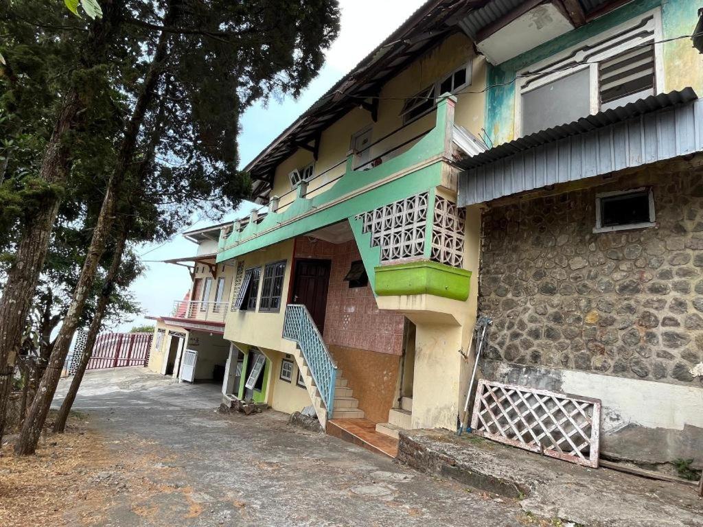 Un edificio antiguo con un cartel al costado. en OYO 93277 Villa Kemiloko Syariah, en Prigen