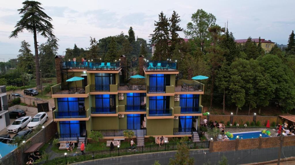 a building with people on the balconies next to a pool at Villa Harmony in Chakvi