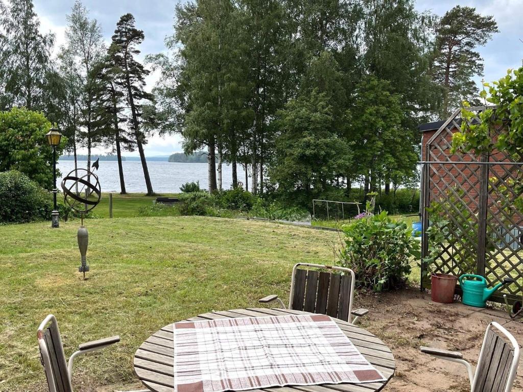 a table and chairs in a yard with a view of the water at 4 star holiday home in KARLSBORG in Karlsborg