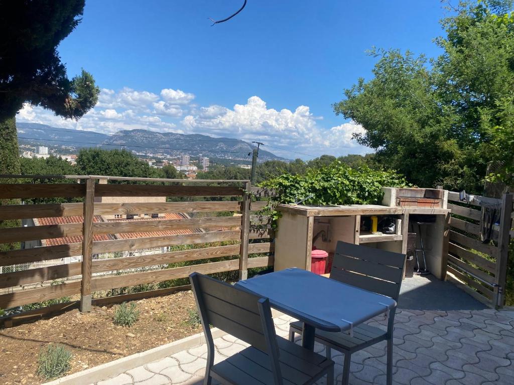 une table et des chaises sur une terrasse avec une clôture dans l'établissement T2 confortable, à La Seyne-sur-Mer