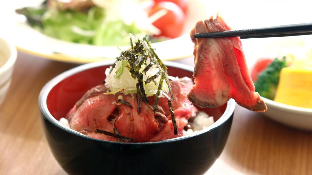 a bowl of food on a table with chopsticks at Hotel Fujita Fukui in Fukui