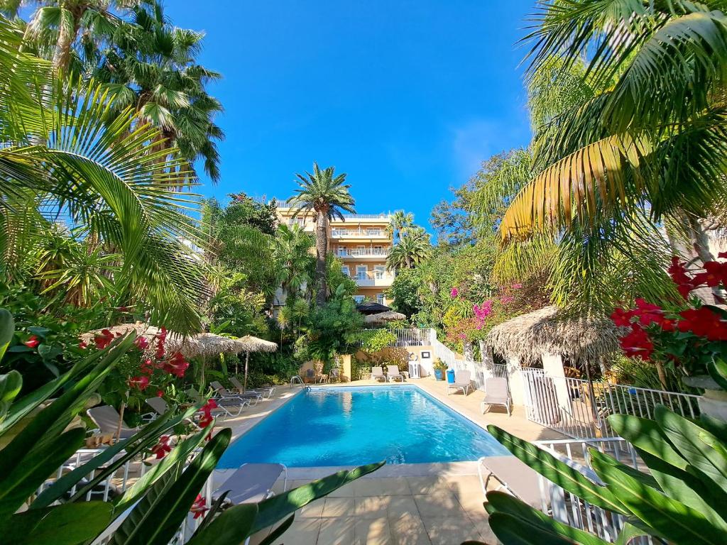 una piscina con palme e un edificio di Residence Veles Plage a Cannes