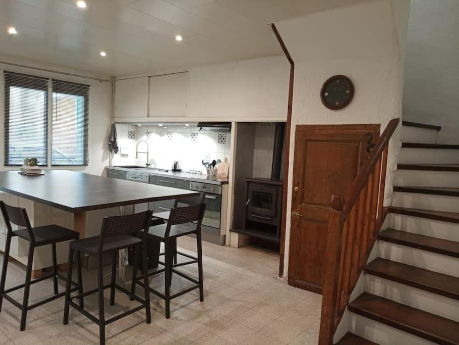 une cuisine avec une table et des chaises ainsi qu'un escalier dans l'établissement Maison de village, à Sigean