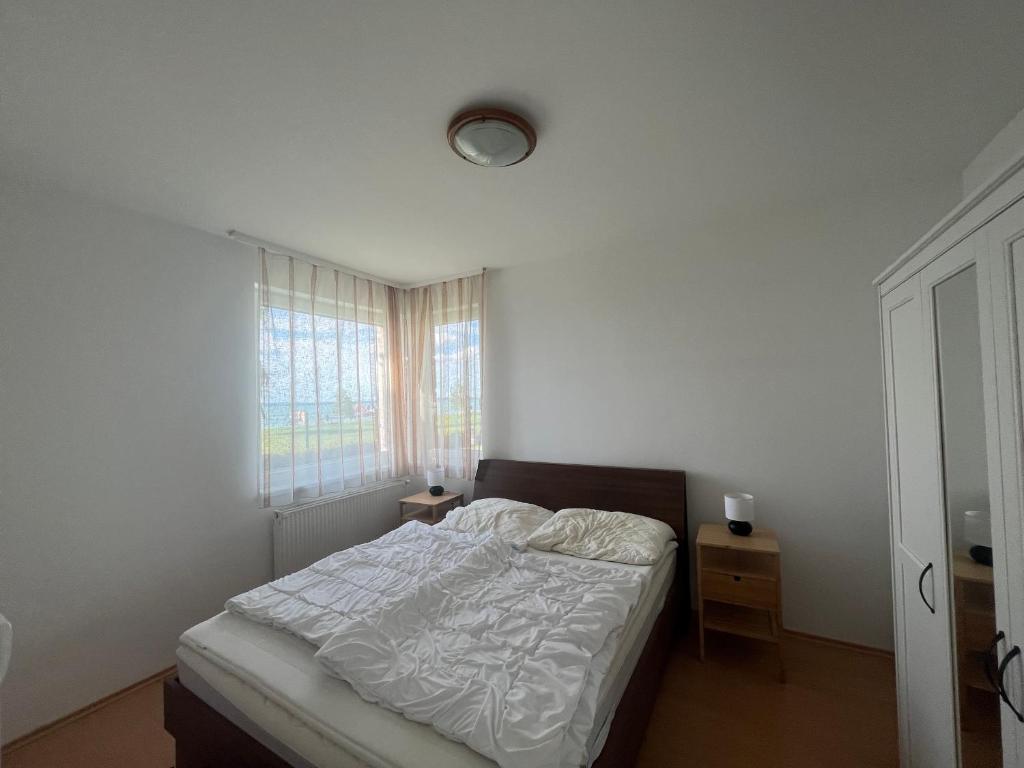 biała sypialnia z łóżkiem i oknem w obiekcie Summer Vibe Siofok 2 Ground floor w Siófoku