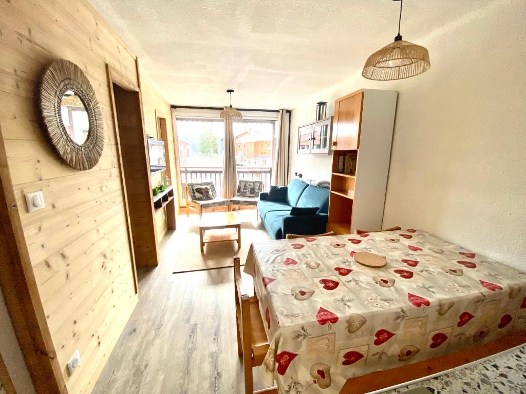 une chambre avec un lit et un salon dans l'établissement Appartement pied des pistes, à Taninges