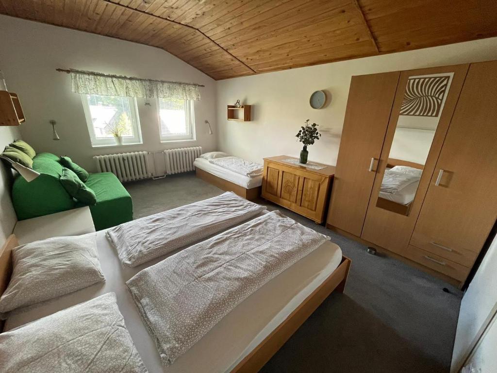 sypialnia z 2 łóżkami i kanapą w obiekcie Chata Ondrášek w mieście Bedřichov