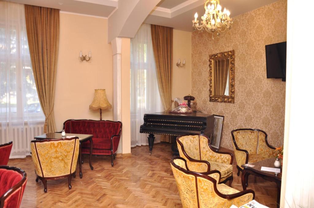 Guest House Anna Caffe في Bezdan: غرفة فيها بيانو وطاولة وكراسي