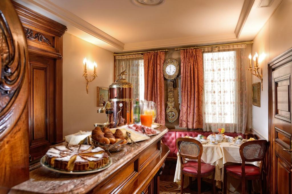 sala śniadaniowa ze stołem i talerzem jedzenia w obiekcie Bellevue Luxury Rooms - San Marco Luxury w Wenecji