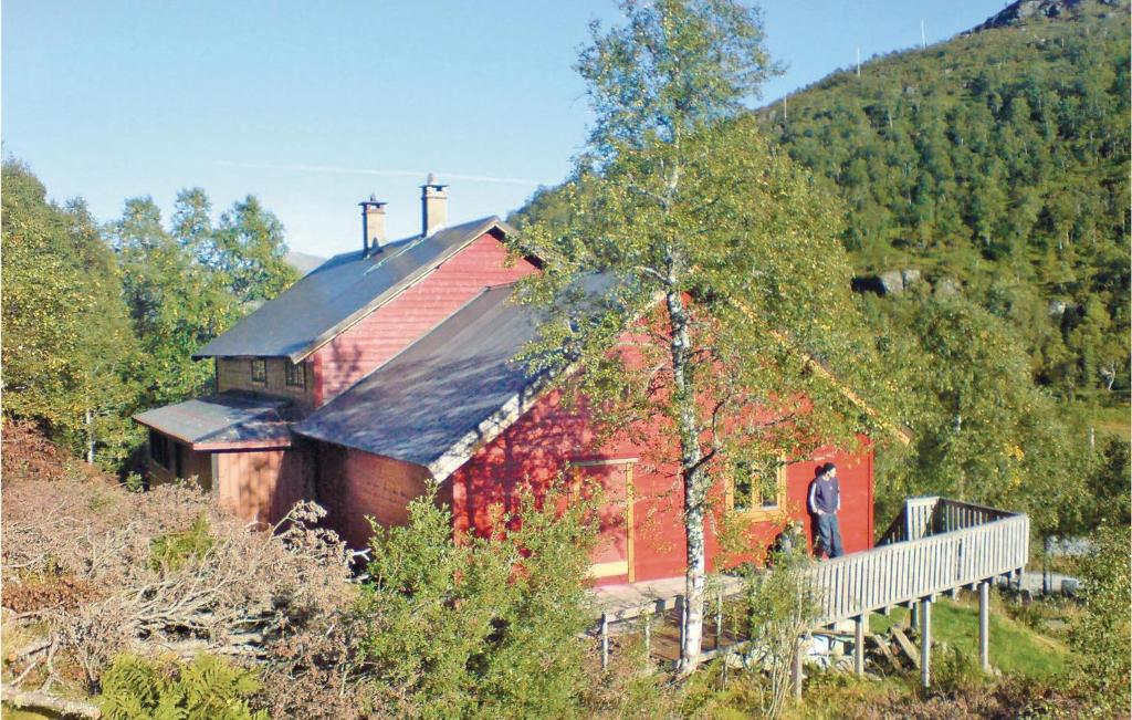 a man standing in front of a red house at Holiday Home Tysse Eikedal in Kleivi