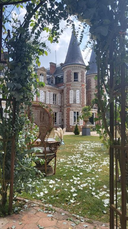 une arche avec un banc devant un château dans l'établissement Château de la PLUMASSERIE, à Fontenay-Trésigny