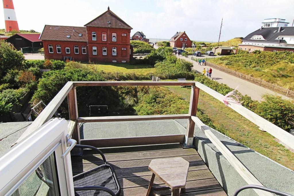 a balcony with chairs and a lighthouse in the background at Haus Rena am Südstrand in Borkum