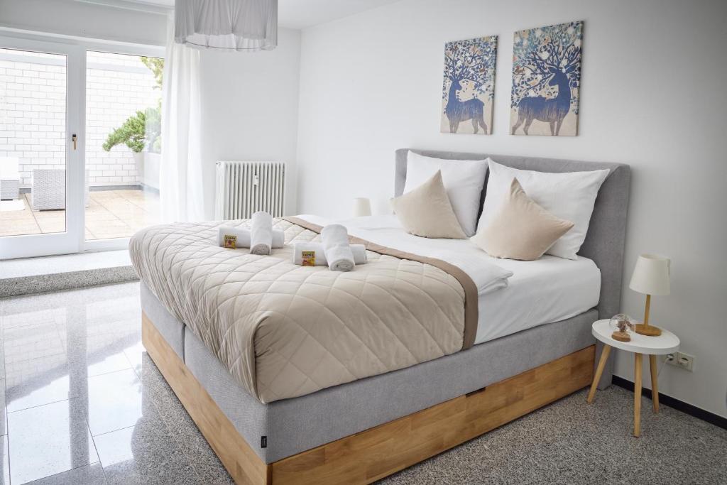a white bedroom with a large bed with white pillows at Penthouse Apartment mit Dachterrasse, Top Lage in Weinheim