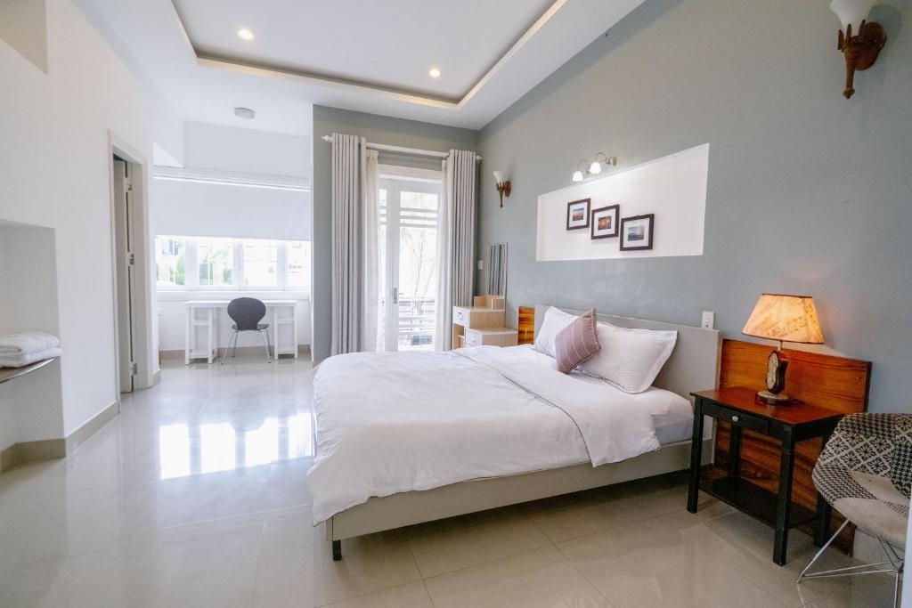 Un dormitorio con una cama y una mesa con una lámpara. en Rose's House Hue, en Hue