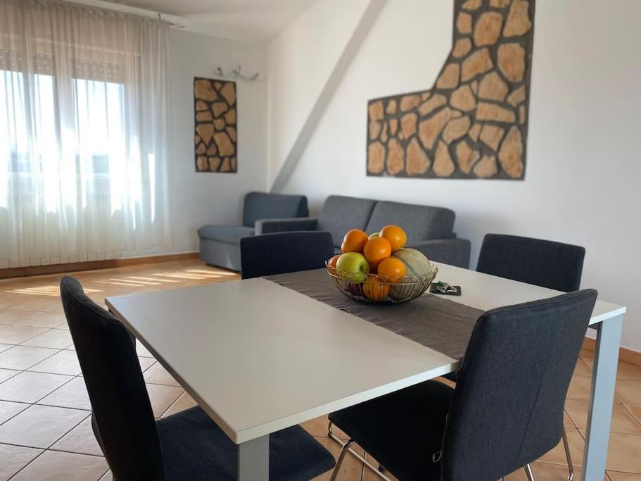 a dining room with a table with a bowl of fruit at Sibilla Tiburtina House Attico Roma con parcheggio in Rome
