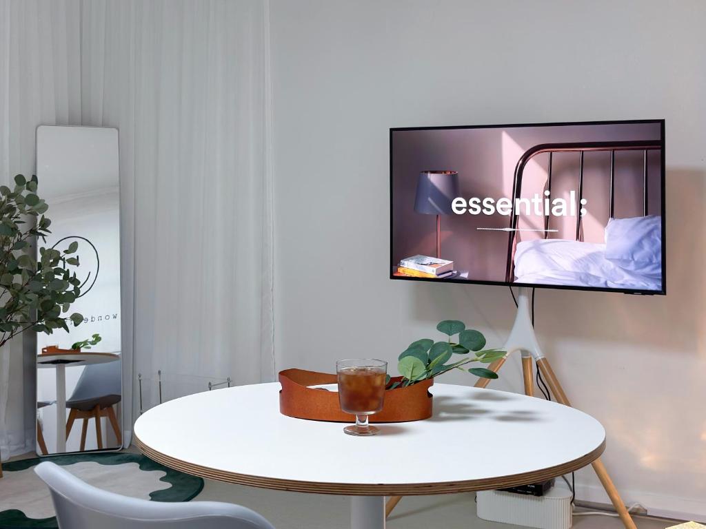 Una habitación con una mesa y un televisor en una pared. en Wellness Stay, en Seúl