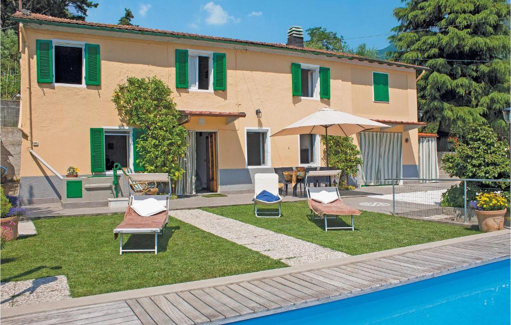 a house with lawn chairs and a swimming pool at Casa Fulvia in Camaiore