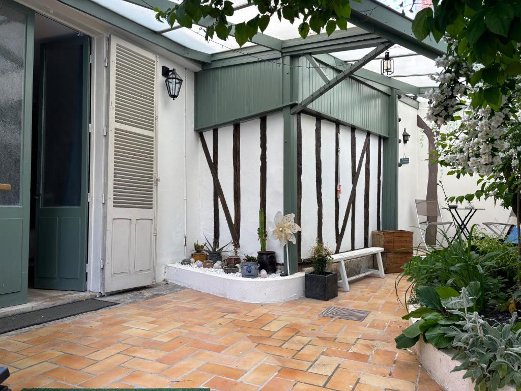 a greenhouse with a door and a patio with plants at La Salle d Attente - Hyper centre in Châlons-en-Champagne