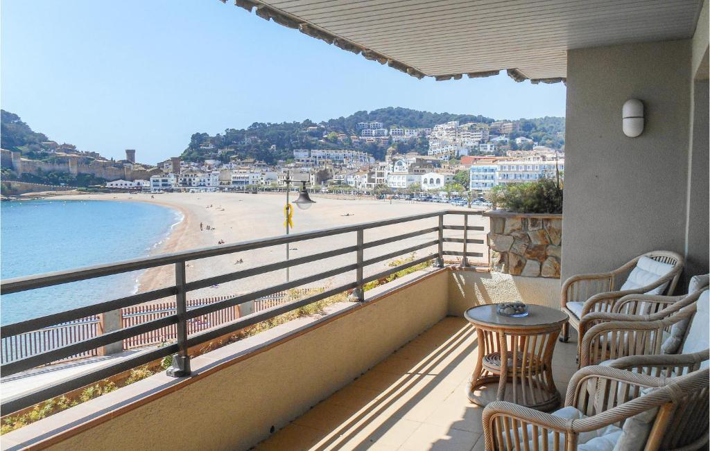 a balcony with chairs and a table and a beach at Lovely Apartment In Tossa De Mar in Tossa de Mar
