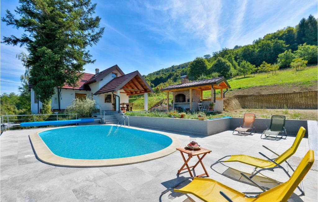 a backyard with a swimming pool and chairs and a house at 3 Bedroom Beautiful Home In Piscanovec in Tuhovec