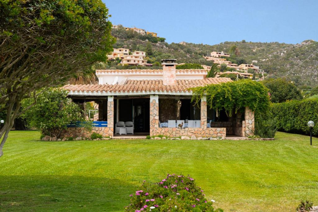 a house with a green lawn in front of it at Villa Tiziana in Costa Rei