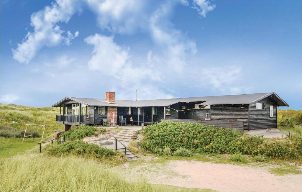 una casa di legno su una spiaggia con un campo erboso di Holiday Home Fanø 60 a Fanø