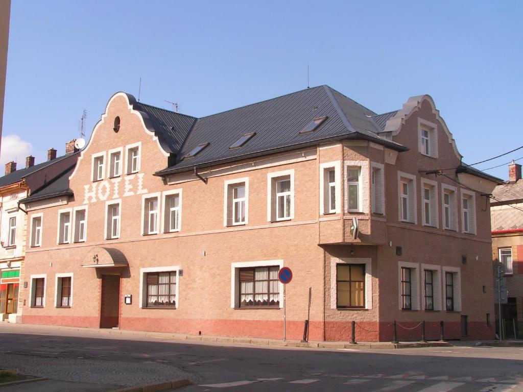 a large brick building on the corner of a street at Hotel Praděd Rýmařov in Rýmařov