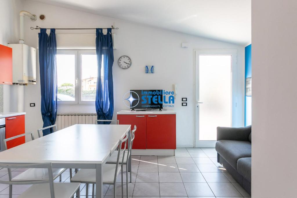 a kitchen and living room with a table and a couch at Condominio Milan in Lido di Jesolo