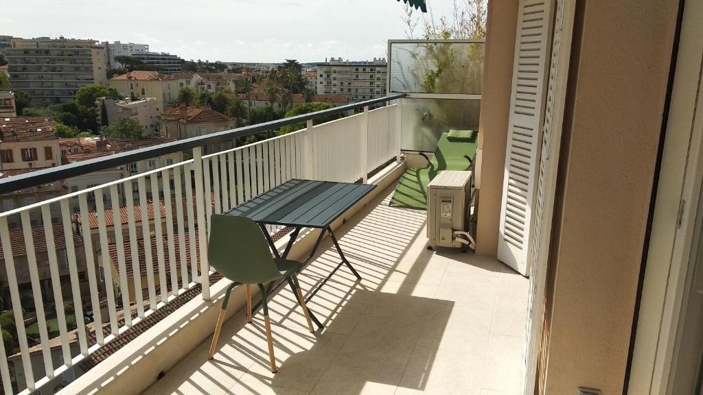 un balcon avec une table et une vue sur une ville dans l'établissement Beau 2 pièces centre de Cannes idéal congres et vacances, à Cannes