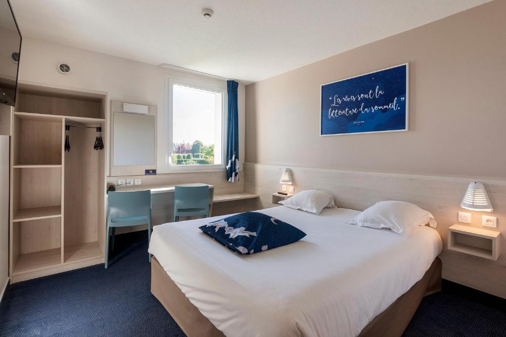 a hotel room with a large bed and a desk at Ace Hôtel Paris Sud Villabe in Villabé