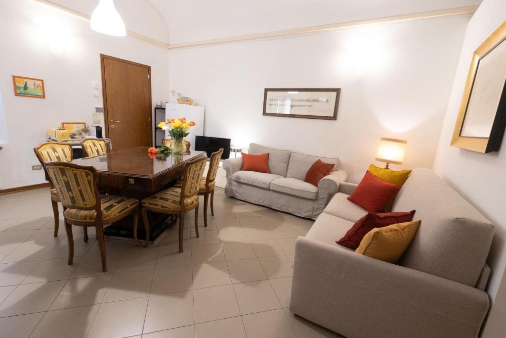 a living room with a table and a couch at Ca' Spadoni, centro storico, piano terra, ingresso indipendente, teatro, parcheggio, in Imola
