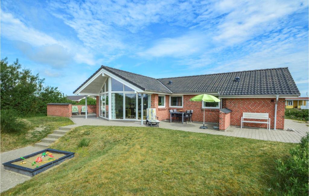 a brick house with a patio and a yard at Holiday Home Lakolk Iiv Denmark in Bolilmark