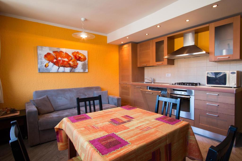 cocina y comedor con mesa y sofá en Ariete Apartments, en Livigno