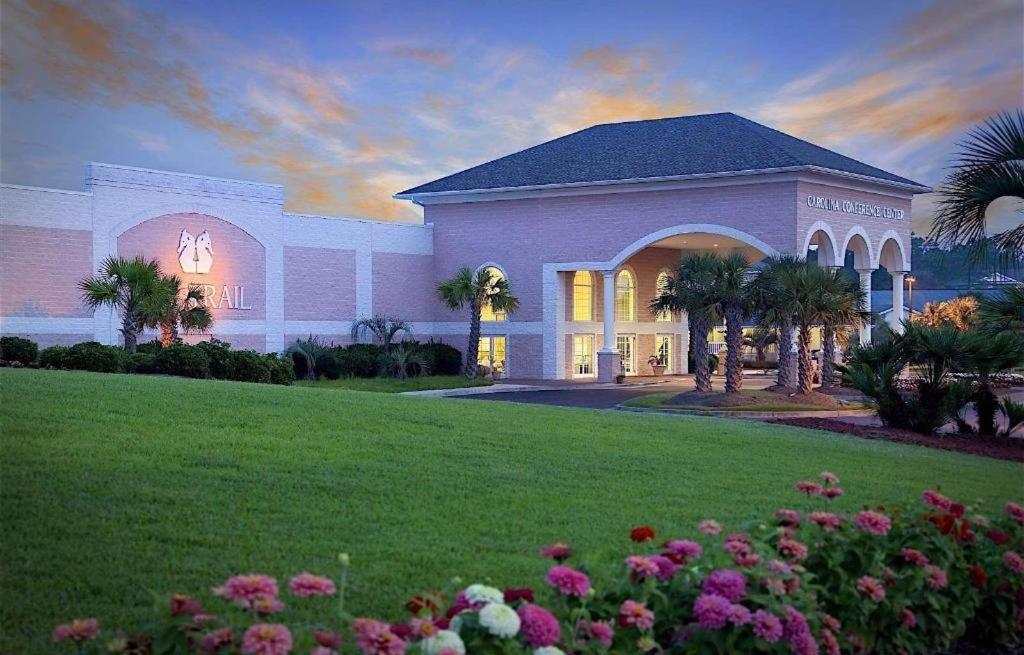 a large house with a lawn and flowers at Sea Trail Golf Resort & Convention Center in Sunset Beach