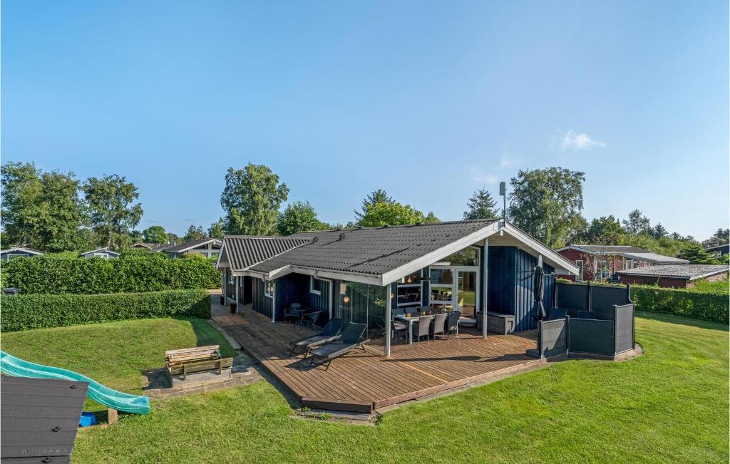a house with a deck in a yard at Four-Bedroom Holiday Home In Hadsund in Nørre Hurup