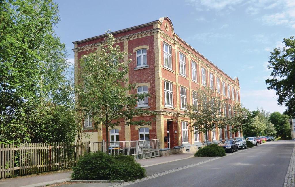 a red brick building on a street with cars parked in front at Nice Home In Auerbach With Wifi in Auerbach