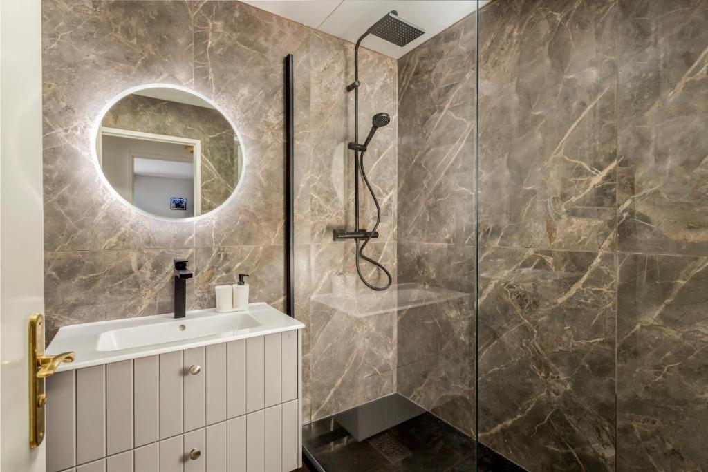 une salle de bain avec une douche avec un lavabo et un miroir dans l'établissement OASIS de tranquillité avec Terrasse à 15 min PARIS, à Choisy-le-Roi