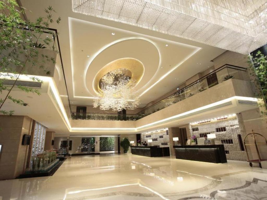 un'ampia hall con un grande lampadario a braccio sul soffitto di White Swan Hotel ChangSha a Changsha