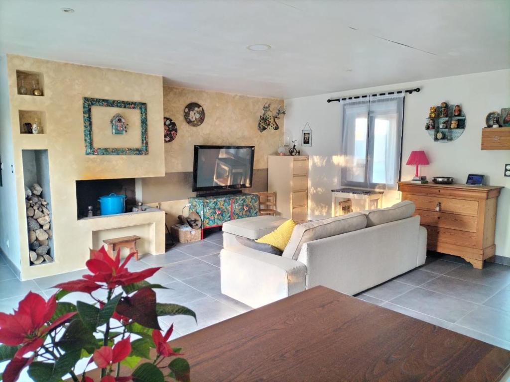 un salon avec un canapé et une télévision dans l'établissement Maison Familiale à la campagne, à Saint-ouen-dʼAunis