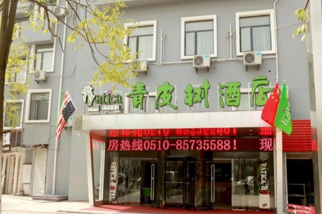 a building with a sign for a restaurant at Vatica JiangSu WuXi Xihu Middle Road Jinhai Park Hotel in Wuxi